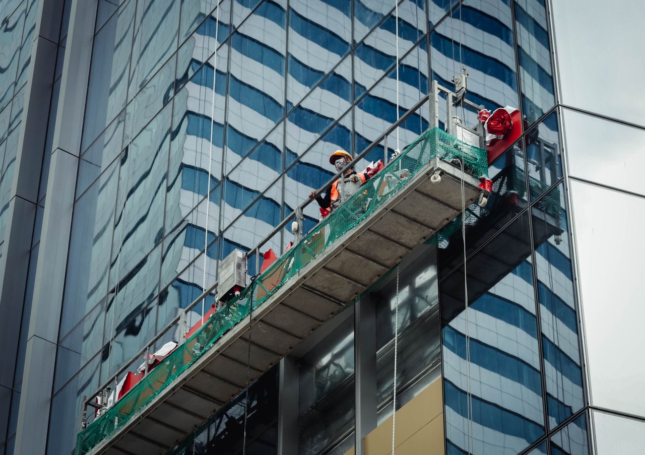 journey Urban worker cleaning windows on a high-rise in Ho Chi Minh City, Vietnam.